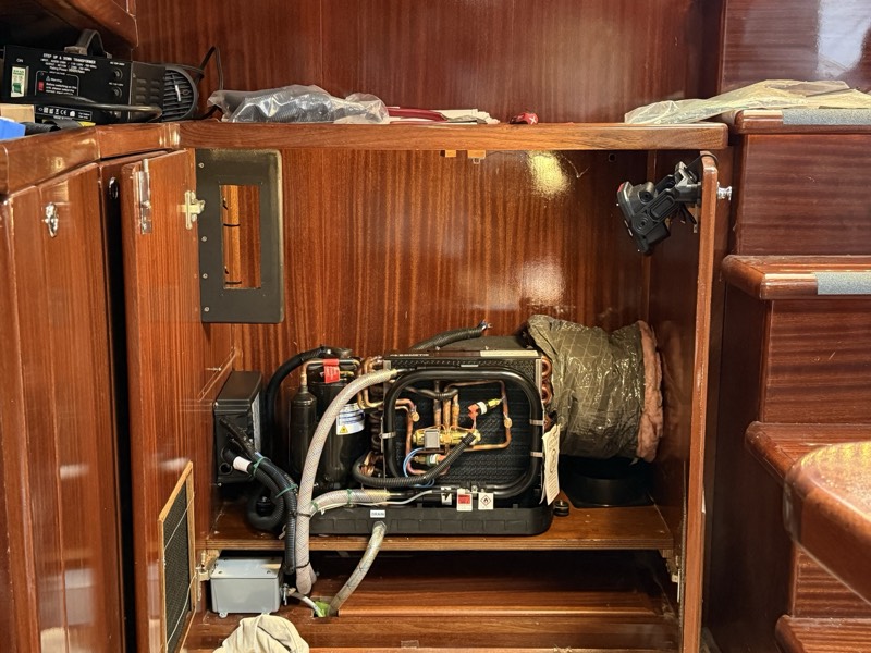 Air conditioning unit installed in a cabinet, with supply ducting